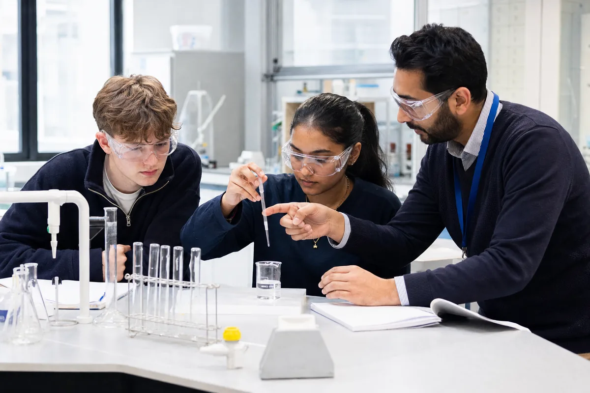 Sixth-form students completing a science practical with a tutor